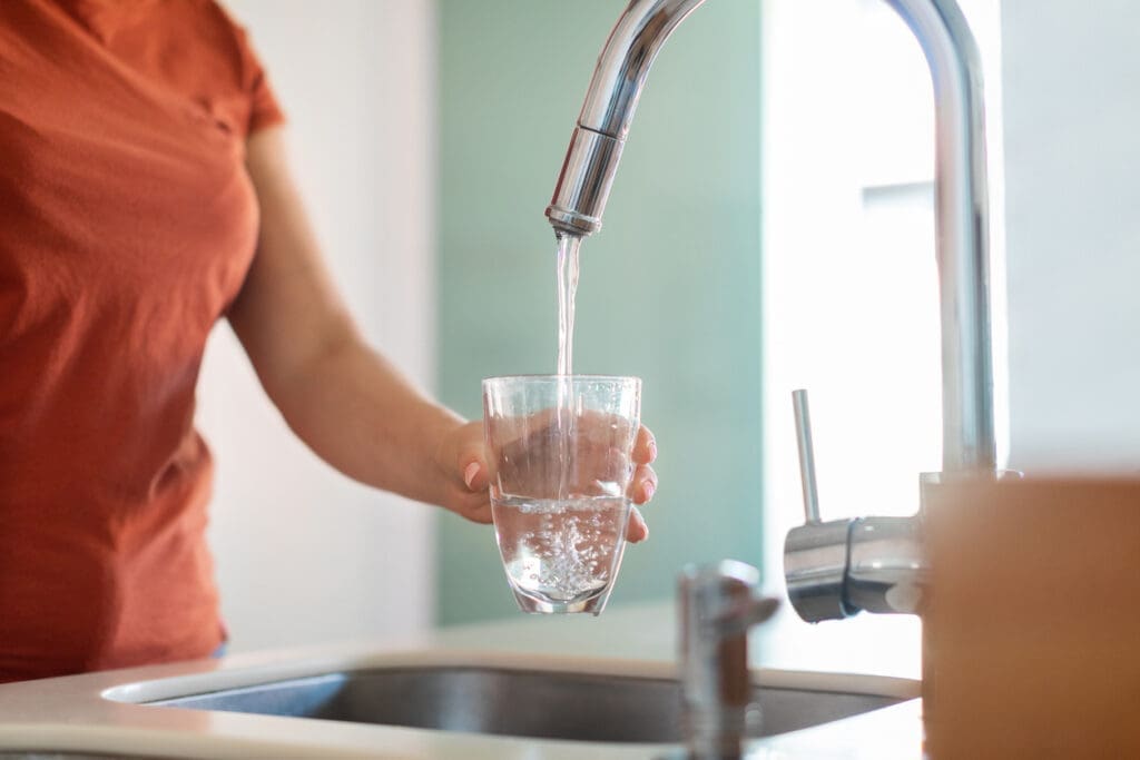 Woman Filling Glass from Sink
